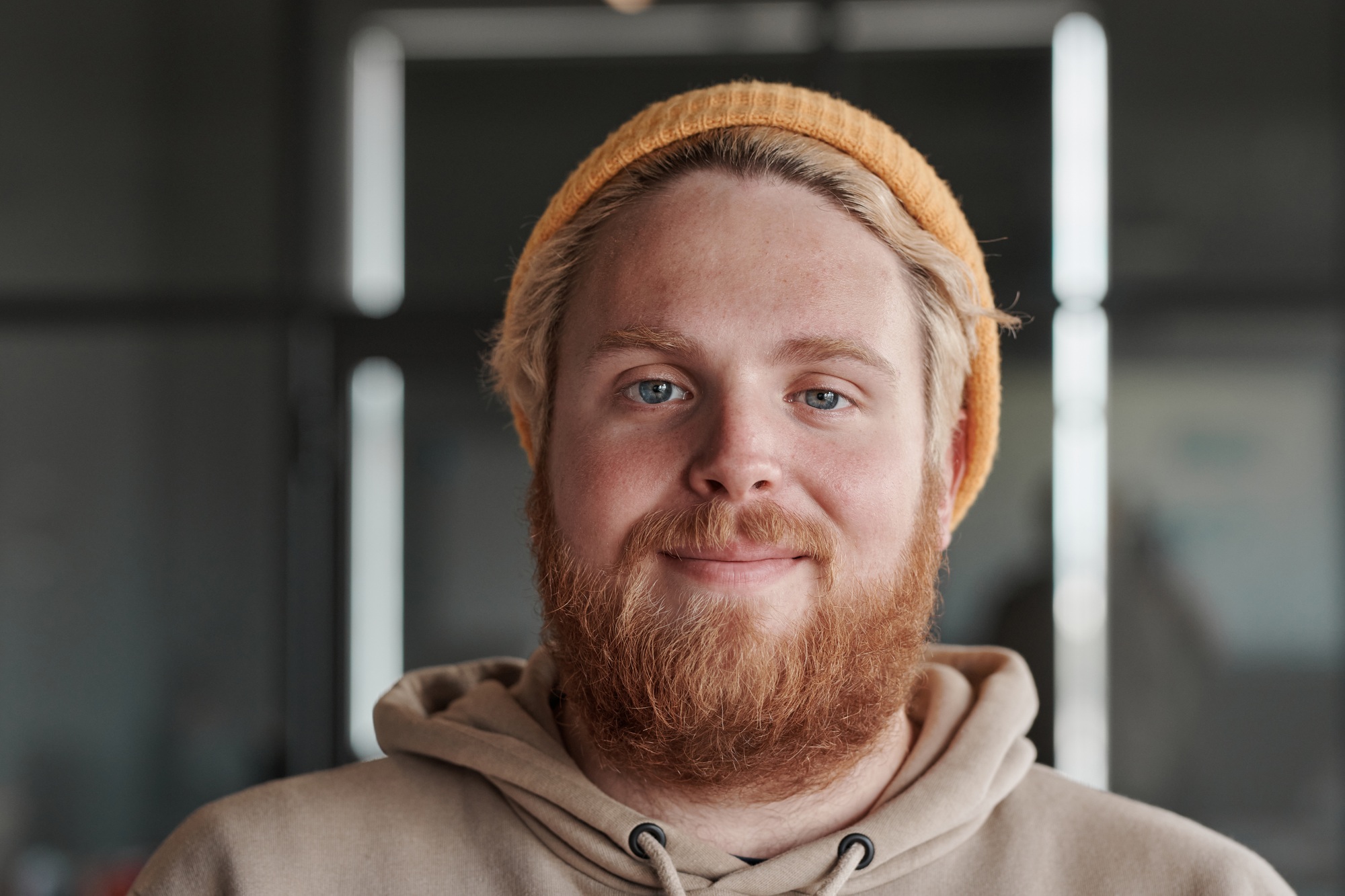 Headshot of red-bearded man in office